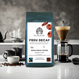 Peru Decaf coffee bag with a coffee-making setup in the background