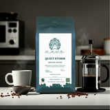 Coffee bag labeled 'Quiet Storm' with a coffee cup, beans, and French press in a kitchen setting.